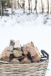 mand met brandhout in de sneeuw