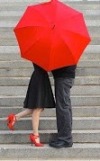stelletje zoent achter een rode paraplu